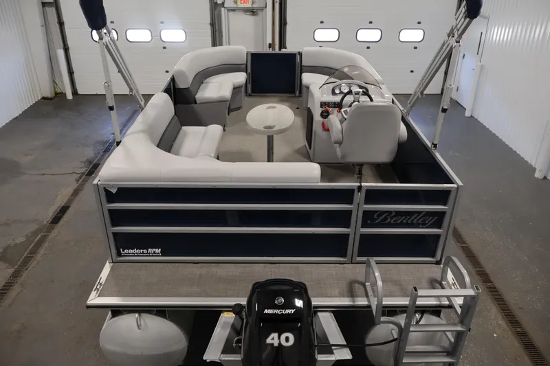 Slide: The Image of 2020 Bentley Pontoons 180 CRUISE in a garage, showcasing seating and steering console. - 9