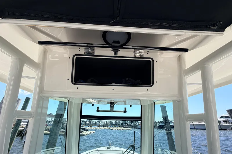 Slide: The Image of 2022 Boston Whaler 250 Outrage boat interior with storage compartment and marina view. - 27