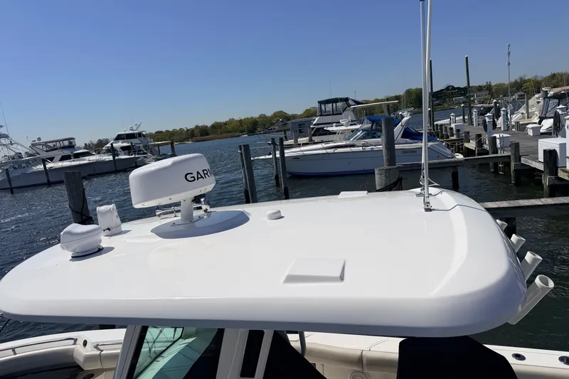 Slide: The Image of 2022 Boston Whaler 250 Outrage docked, featuring Garmin radar, surrounded by other boats. - 30