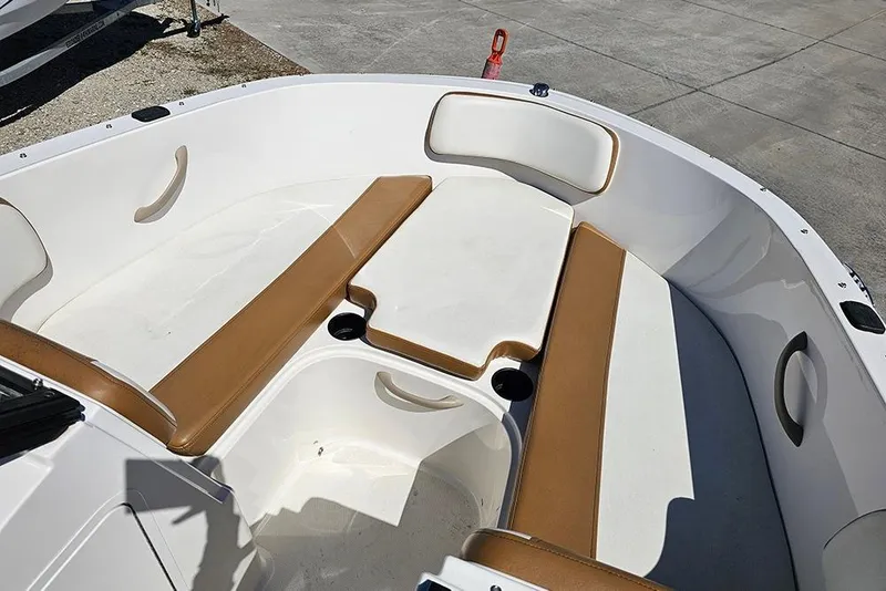 Slide: The Image of 2021 Bayliner VR4 Bowrider OB interior with tan and white seating, cup holders, and spacious layout. - 19