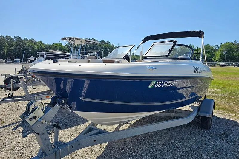 Slide: The Image of 2021 Bayliner VR4 Bowrider OB on trailer, blue and white, parked outdoors. - 5