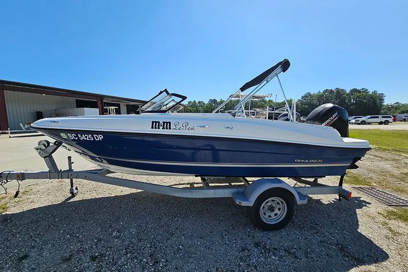 Slide: The Image of 2021 Bayliner VR4 Bowrider OB on trailer, parked outdoors under clear blue sky. - 6