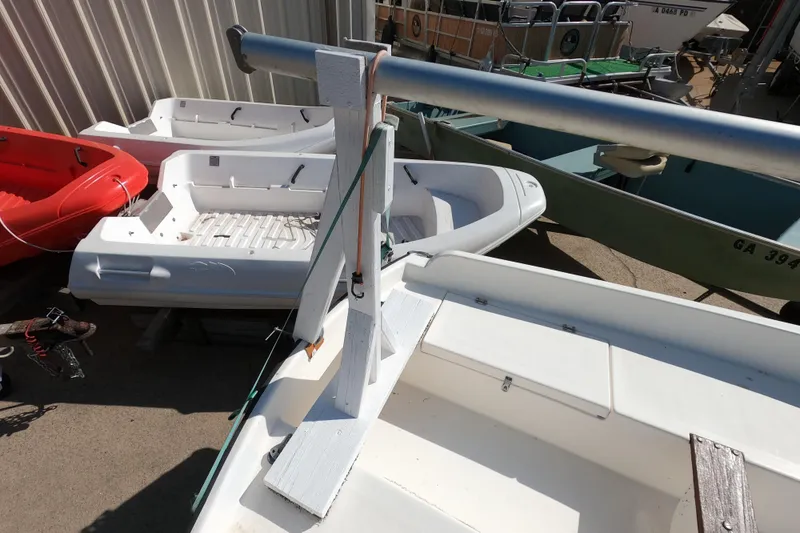 Slide: The Image of 1978 Newport 16 sailboat with mast, surrounded by other small boats in a storage area. - 4