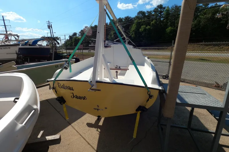 Slide: The Image of 1978 Newport 16 sailboat with yellow hull, named "Bateau Jaune," docked outdoors. - 9