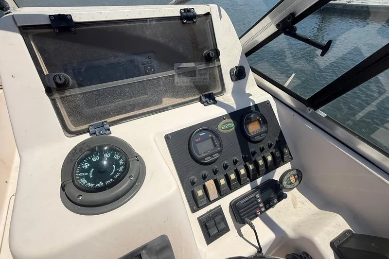 Slide: The Image of Control panel of a 2005 Grady-White Tournament 225 boat with compass and gauges. - 5