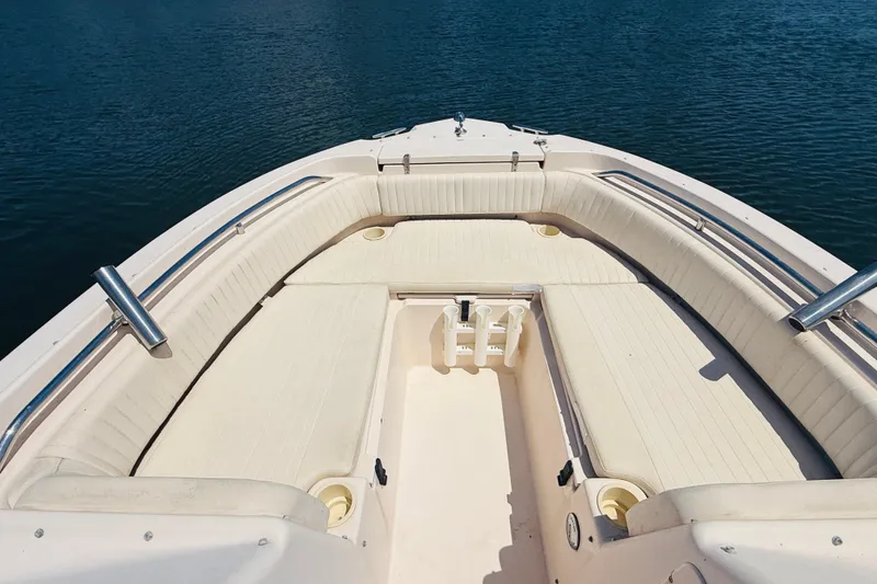 Slide: The Image of 2005 Grady-White Tournament 225 boat interior with cushioned seating, on calm water. - 6