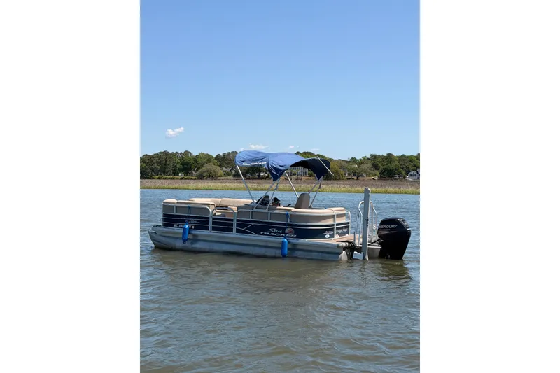 The Image of 2019 SUNTRACKER Party Barge 20 DLX pontoon boat on calm water with blue canopy. - 0