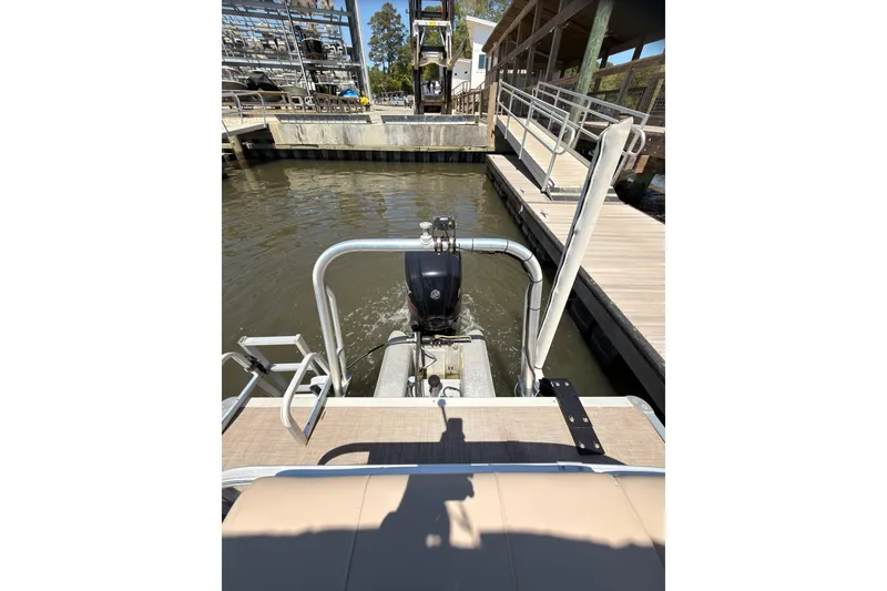 Slide: The Image of 2019 SUNTRACKER Party Barge 20 DLX at dock, rear view with motor and water. - 14