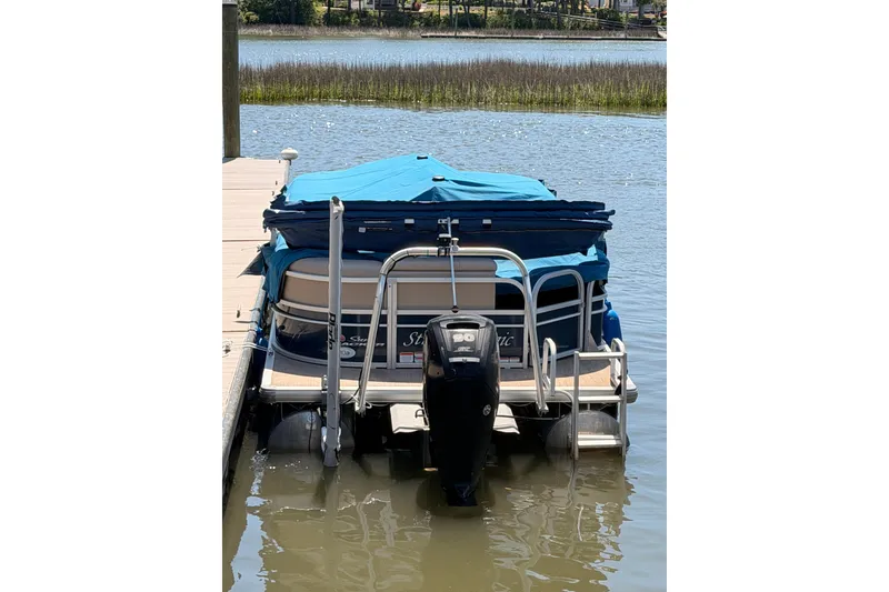 Slide: The Image of 2019 SUNTRACKER Party Barge 20 DLX pontoon boat docked on a calm lake. - 18