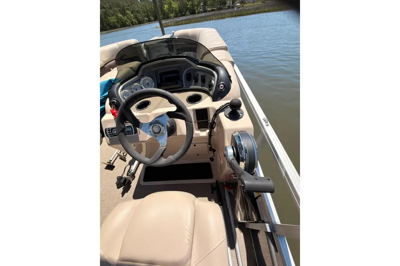 Slide: The Image of 2019 SUNTRACKER Party Barge 20 DLX helm with steering wheel and controls on a lake. - 7