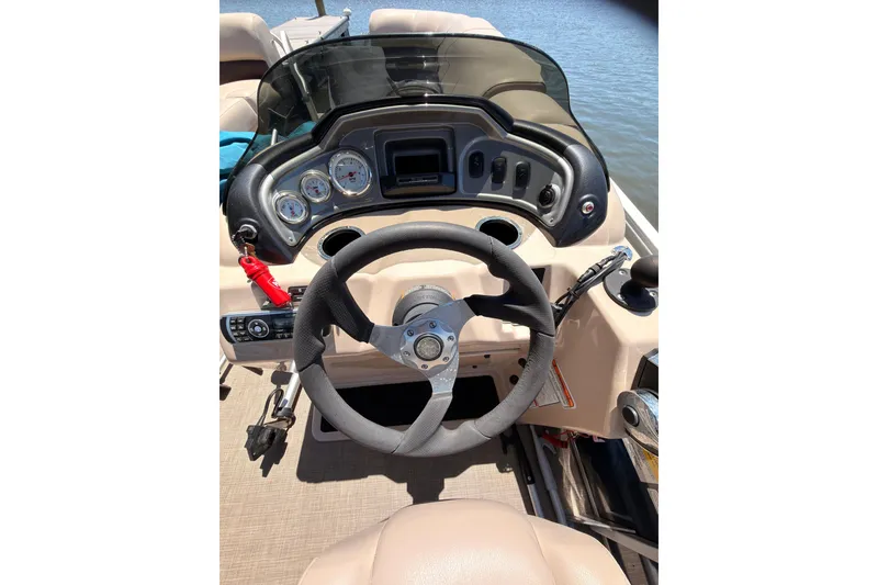 Slide: The Image of 2019 SUNTRACKER Party Barge 20 DLX steering console with gauges and controls. - 8