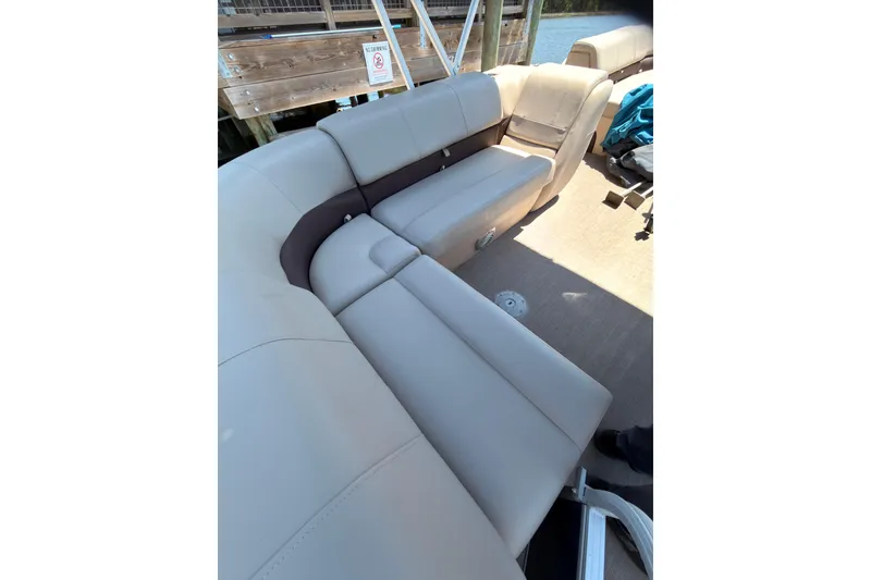 Slide: The Image of 2019 SUNTRACKER Party Barge 20 DLX interior seating area with beige upholstery. - 9