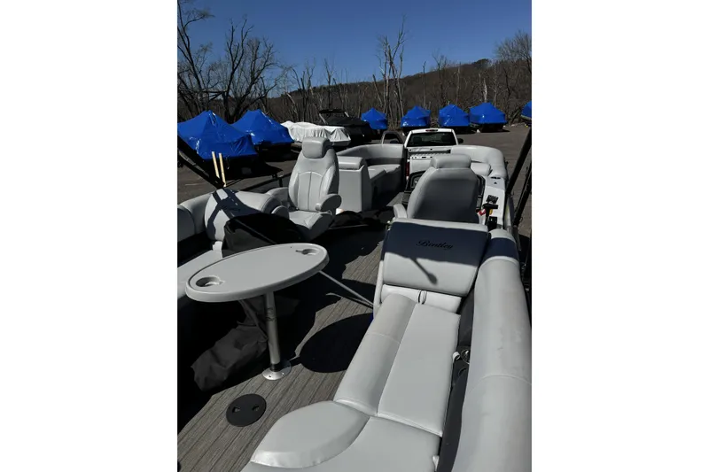Slide: The Image of 2021 Bentley Pontoons Legacy 243 DL Navigator interior with gray seating and table. - 12