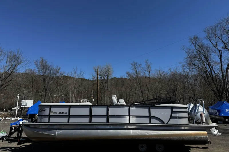 Slide: The Image of 2021 Bentley Pontoons Legacy 243 DL Navigator on trailer, parked outdoors under clear blue sky. - 13
