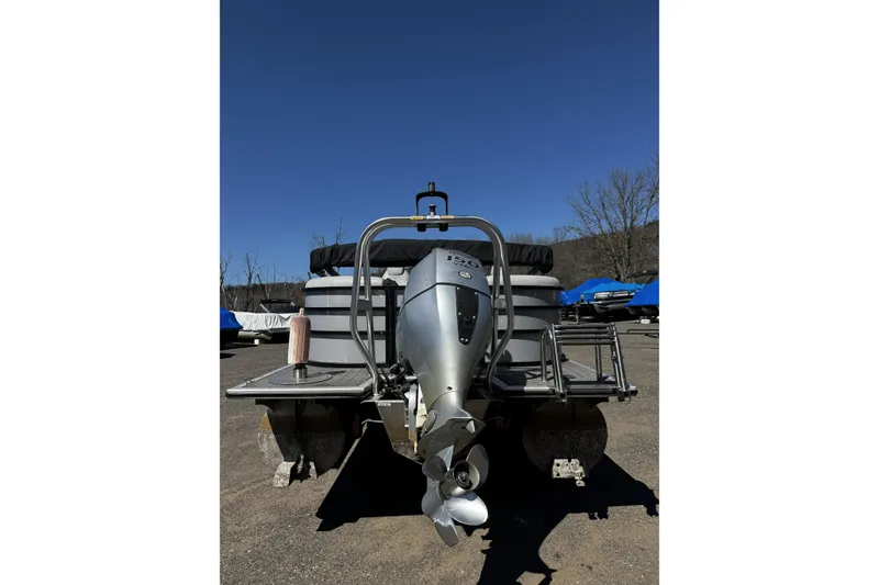 Slide: The Image of 2021 Bentley Pontoons Legacy 243 DL Navigator with powerful outboard motor, parked outdoors. - 3