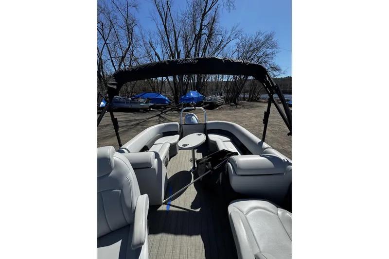 Slide: The Image of 2021 Bentley Pontoons Legacy 243 DL Navigator with seating and canopy, parked outdoors. - 9