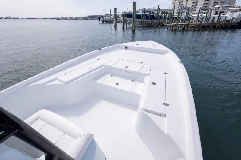 Slide: The Image of 2019 Blazer Bay 2400 boat docked at marina, featuring spacious deck and seating. - 10