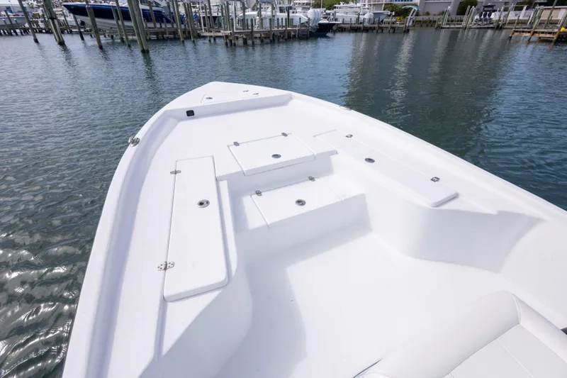 Slide: The Image of 2019 Blazer Bay 2400 boat deck with storage compartments, docked in a marina. - 11