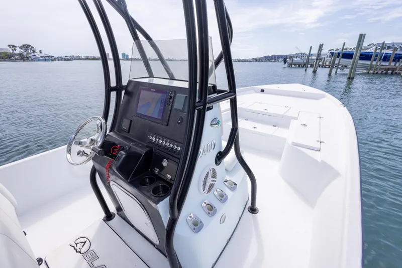 Slide: The Image of 2019 Blazer Bay 2400 boat dashboard with steering wheel and navigation system on water. - 14
