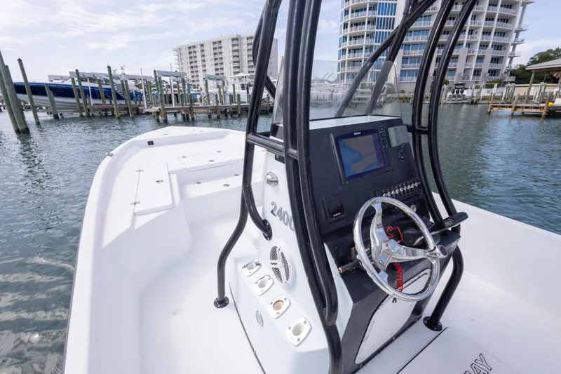 Slide: The Image of 2019 Blazer Bay 2400 boat with modern console, docked near waterfront buildings. - 17