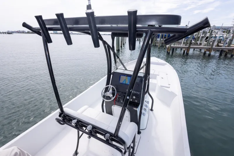 Slide: The Image of 2019 Blazer Bay 2400 boat with T-top and console, docked by the water. - 19
