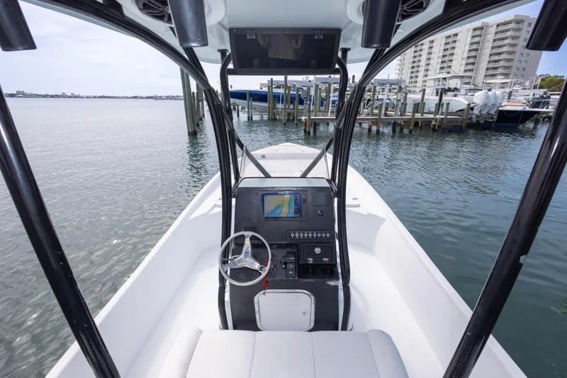 Slide: The Image of 2019 Blazer Bay 2400 boat with modern console, docked near waterfront buildings. - 20