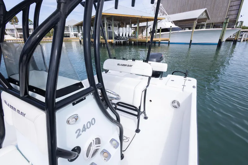 Slide: The Image of 2019 Blazer Bay 2400 boat docked in marina, showcasing sleek design and seating area. - 23