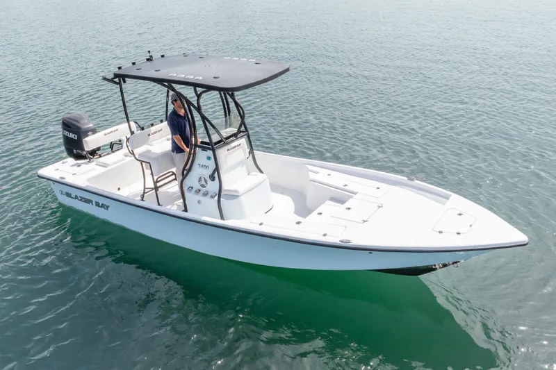 Slide: The Image of 2019 Blazer Bay 2400 boat on water, featuring sleek design and Suzuki outboard motor. - 25
