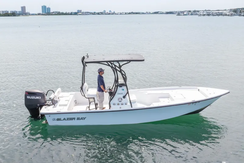 Slide: The Image of 2019 Blazer Bay 2400 boat on water with Suzuki outboard motor. - 26