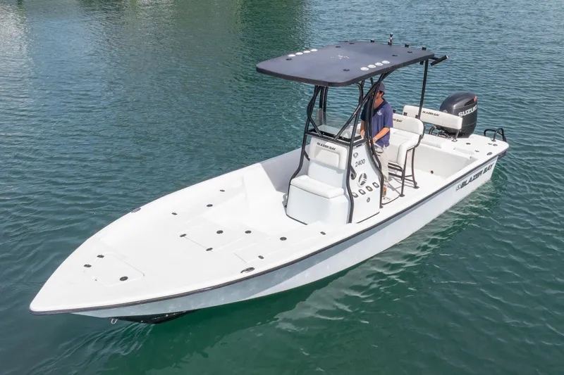 Slide: The Image of 2019 Blazer Bay 2400 boat on water, featuring sleek design and Suzuki outboard motor. - 27