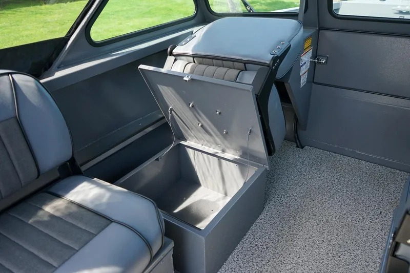 Slide: The Image of 2026 Alumaweld Talon 18 interior with open storage compartment and gray seating. - 13