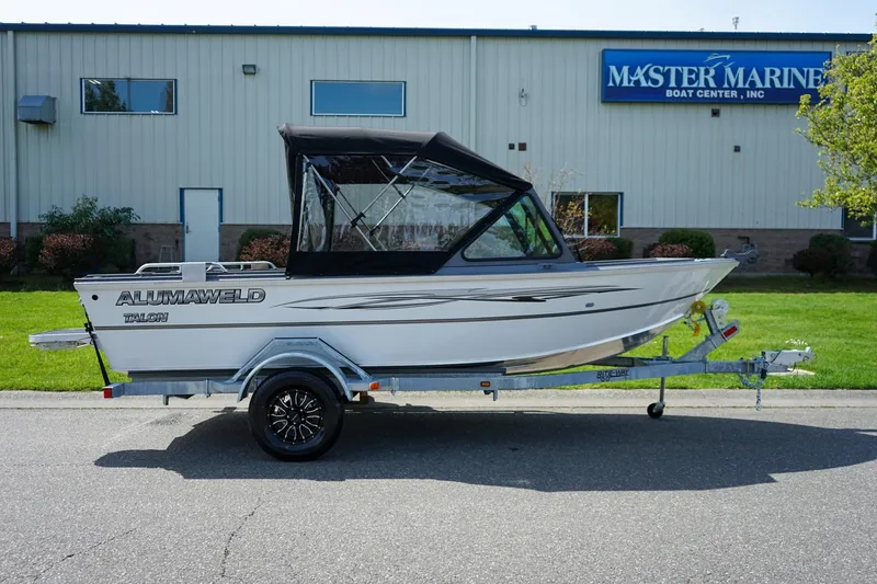 Slide: The Image of 2026 Alumaweld Talon 18 boat on trailer outside Master Marine Boat Center. - 2