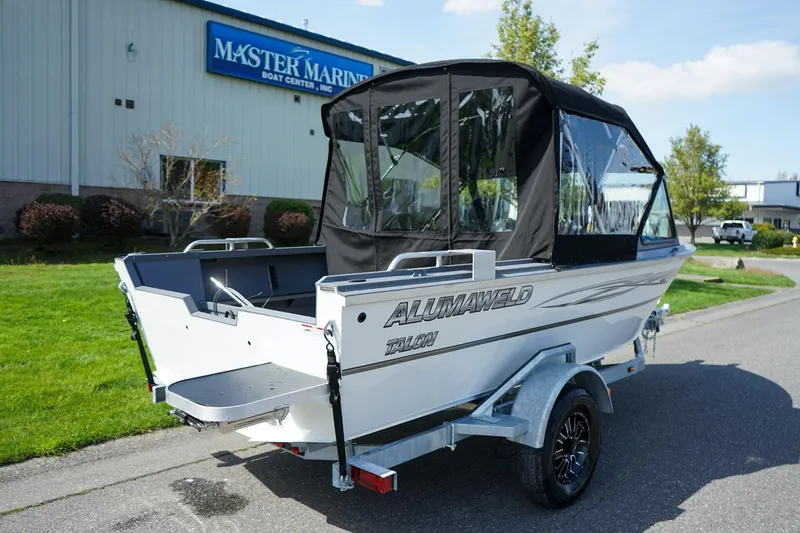 Slide: The Image of 2026 Alumaweld Talon 18 boat with canopy, parked outside Master Marine Boat Center. - 3