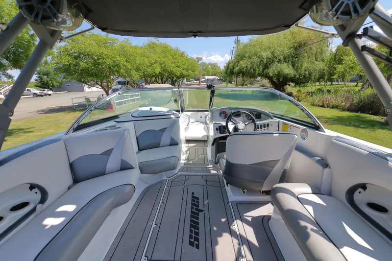 Slide: The Image of Speakers mounted on a 2018 Sanger 212 SL boat, under a canopy with trees in the background. - 9