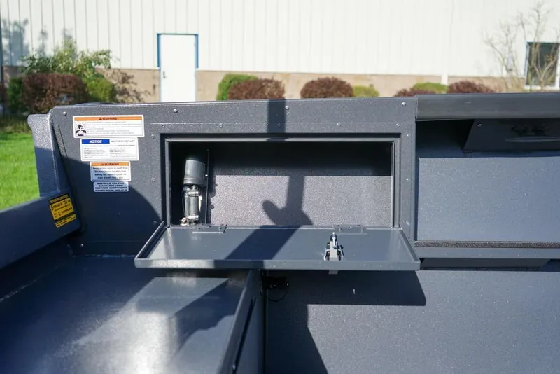 Slide: The Image of 2026 Alumaweld Adventurer 20 boat interior with storage compartment and warning labels. - 10