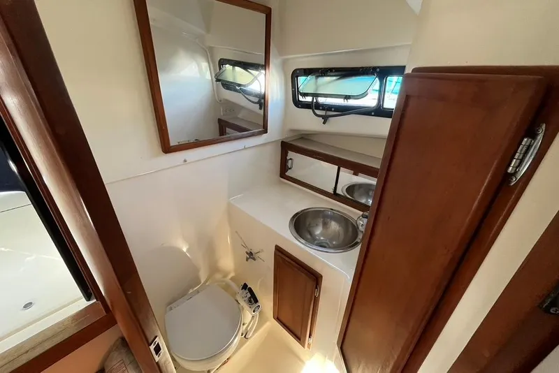 Slide: The Image of 1992 Rampage 28 Sportsman boat bathroom with sink, toilet, and mirror. - 11