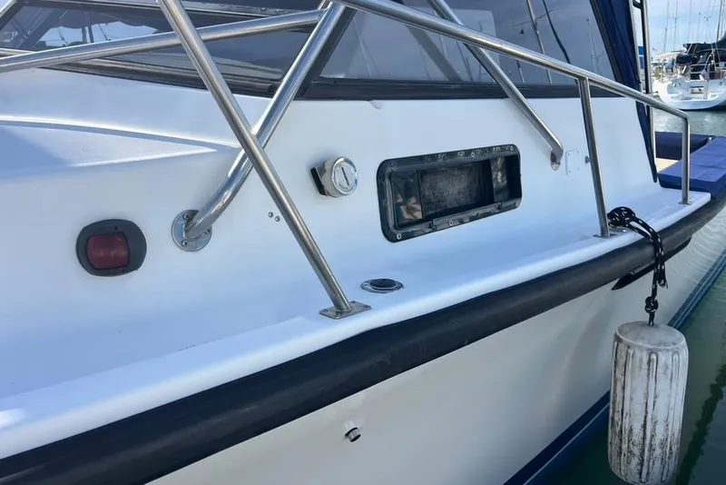 Slide: The Image of 1992 Rampage 28 Sportsman boat with railing and dock bumper in marina. - 4