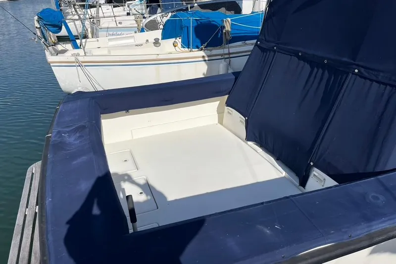 Slide: The Image of 1992 Rampage 28 Sportsman boat with blue seating, docked at marina. - 5