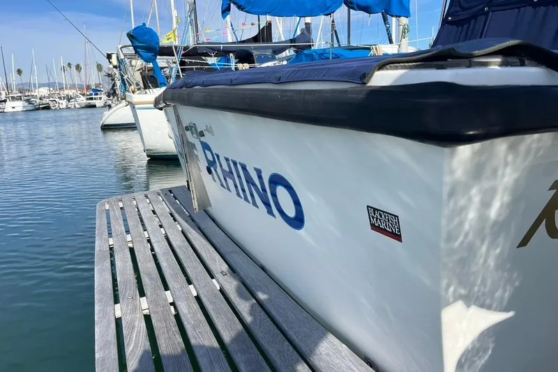 Slide: The Image of 1992 Rampage 28 Sportsman boat docked in marina, featuring "RHINO" lettering. - 6