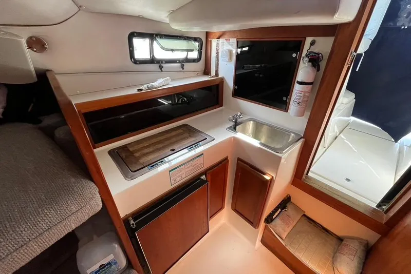 Slide: The Image of 1992 Rampage 28 Sportsman boat interior with kitchenette, sink, and storage cabinets. - 9