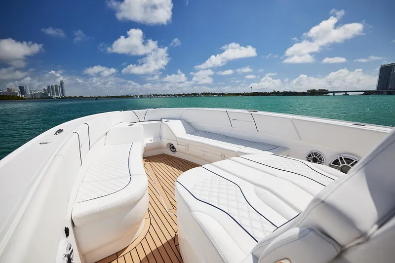 Slide: The Image of Luxurious 2024 Midnight Express boat with white seating, cruising on turquoise waters under a blue sky. - 10