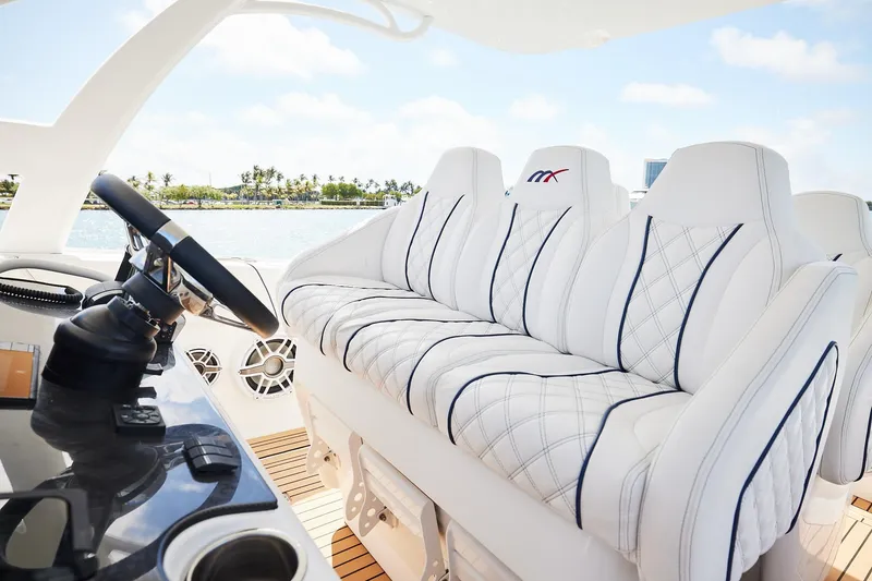 Slide: The Image of Luxurious 2024 Midnight Express boat interior with plush white seating and sleek steering wheel. - 14