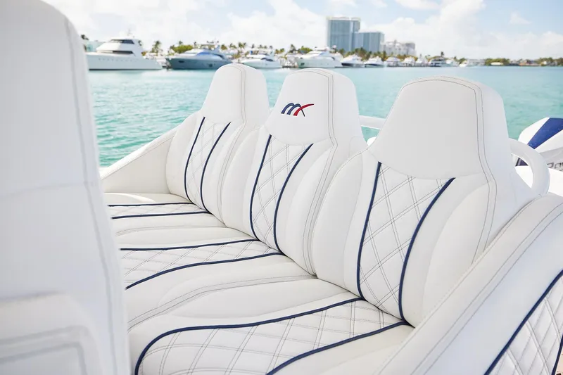 Slide: The Image of Luxurious white seating on a 2024 Midnight Express boat, with yachts in the background. - 15