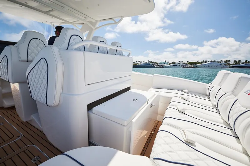 Slide: The Image of Luxurious 2024 Midnight Express boat interior with white seating, docked by turquoise waters. - 16