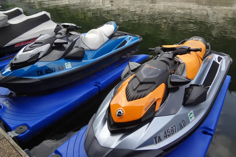 The Image of 2021 Seadoo GTI 170 SE jet skis in blue and orange, docked on water. - 0