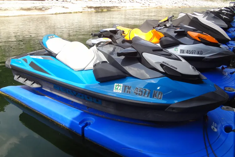 Slide: The Image of 2021 Seadoo GTI 170 SE jet ski in blue, docked on water. - 2