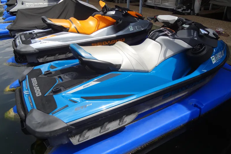 Slide: The Image of 2021 Seadoo GTI 170 SE jet ski in blue, docked alongside other watercraft. - 3