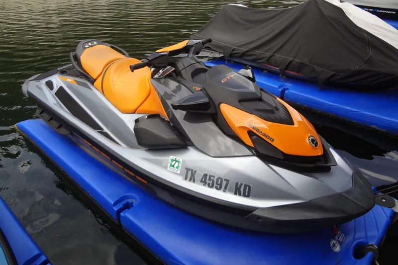 Slide: The Image of 2021 Seadoo GTI 170 SE jet ski with orange and gray design on water. - 4