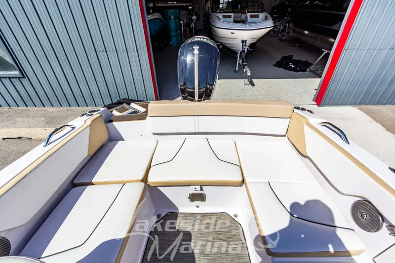 Slide: The Image of 2019 Glastron GTD 180 boat interior with beige and white seating, docked near a marina. - 13