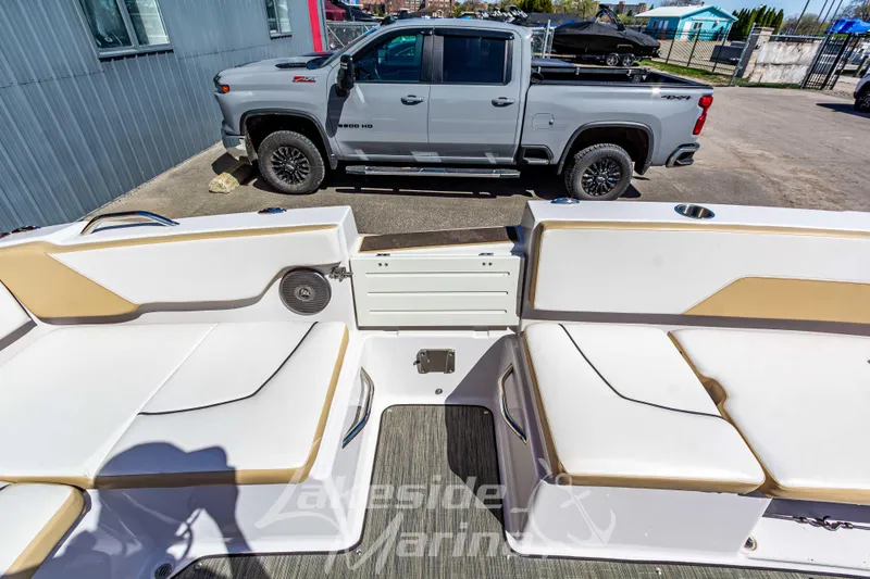 Slide: The Image of 2019 Glastron GTD 180 boat interior with seating, parked beside a gray pickup truck. - 15